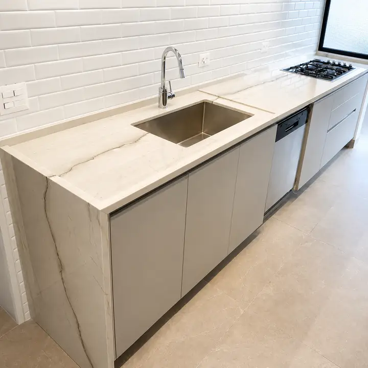 Bancada de pedra clara em cozinha planejada